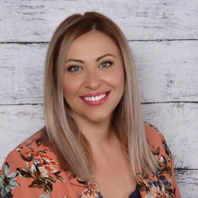 A woman with blonde hair and a floral shirt.