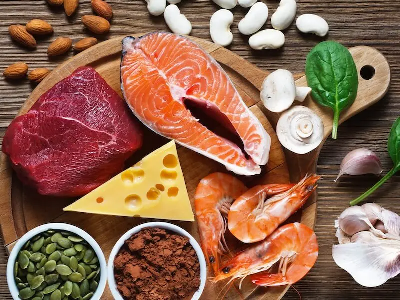 A wooden table topped with lots of different foods.