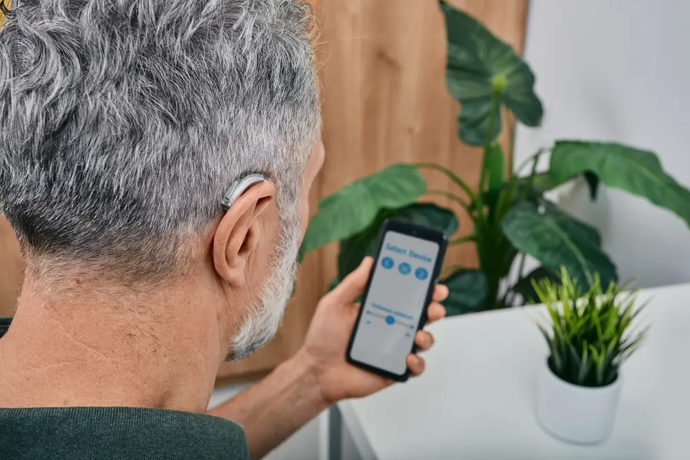 A man with grey hair looking at his phone.