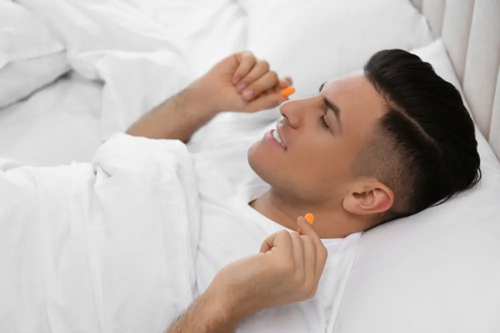 A man laying in bed with his mouth open.