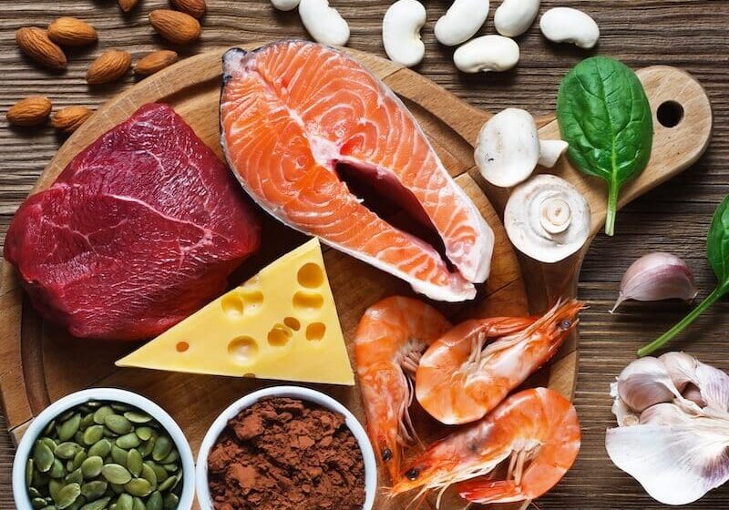 A wooden table topped with lots of different foods.