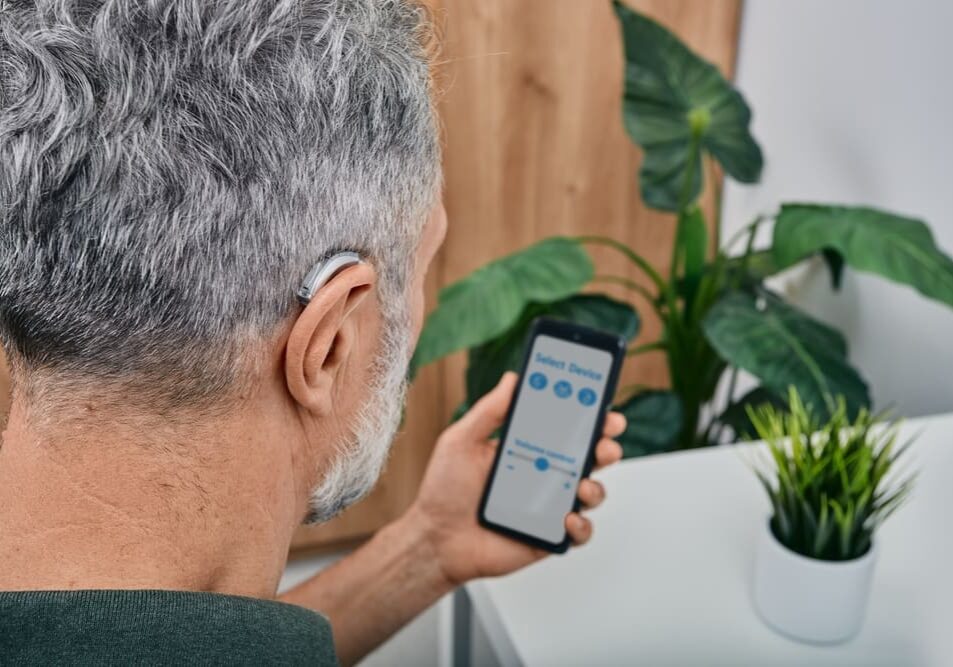 A man with grey hair looking at his phone.